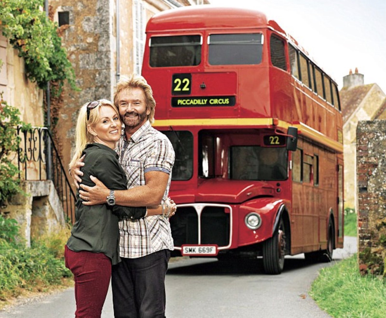 Noel and Liz Edmonds in front of a red Routemaster bus